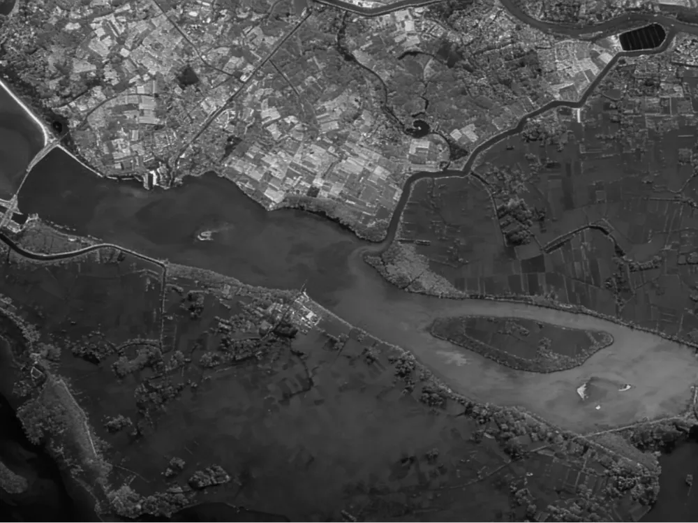 SAR radar satellite image in grayscale showing coastal urban area, river delta and flooded agricultural land – all-weather surveillance by Sensing PLUM platform